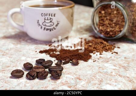 tasse Kaffee und Kaffeebohnen auf dem Küchentisch Stockfoto