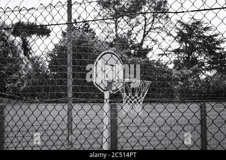 Basketballkorb auf einem Spielplatz hinter einem Metallzaun (Pesaro, Italien, Europa) Stockfoto