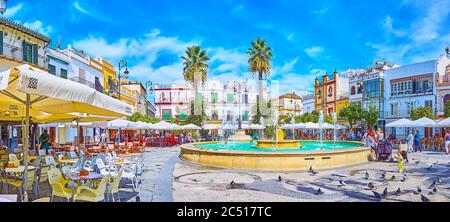 SANLUCAR, SPANIEN - 22. SEPTEMBER 2019: Der historische Plaza del Cabildo ist ein beliebter Ort mit einem erfrischenden Brunnen, erhaltenen Stadthäusern und Outdo Stockfoto