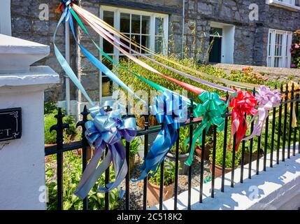 Tugend-Signalisierung mit farbigen Bändern auf Geländern außerhalb eines Mittelklassehauses in Castletown, Isle of man Stockfoto