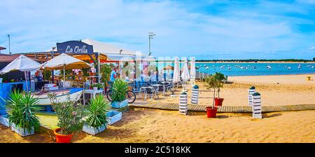 SANLUCAR, SPANIEN - 22. SEPTEMBER 2019: Panorama des Strandes von Calzada am Guadalquivir und landschaftlich reizvolle Sommerrestaurant mit Sonnenschirmen und Pflanzen in Töpfen, Stockfoto