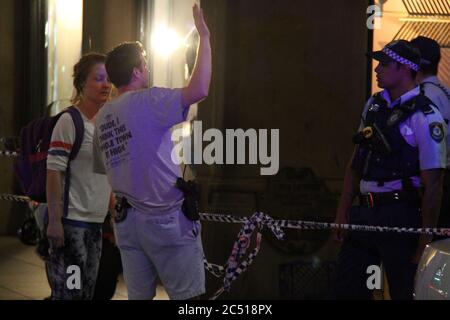 Was wie ein Polizist in Zivil aussah, spricht mit einem Passanten, nachdem das Queen Victoria Building (QVB) in Sydney geschlossen ist. Stockfoto