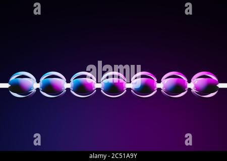 3D-Illustration einer neon-rosa und blauen Kugel mit Blütenblättern, die auf einer Schnur in Form einer Perle auf schwarzem Hintergrund aufgereiht sind. Cyber Halskette in virtuellen re Stockfoto