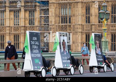 Sieben Werbefahrräder überqueren die Westminster Bridge und repräsentieren die 12,000 Menschen, die sich der ersten virtuellen Lobby der Climate Coalition anschließen, die über 250 Abgeordnete trifft, um eine Politik für eine faire und grüne Erholung in Großbritannien zu fordern. Stockfoto