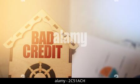 Bad Credit Worte auf Holz-Home-Modell mit finanziellen Diagramm Hintergrund. Schulden, Hauskredit, Immobilienkonzept Stockfoto