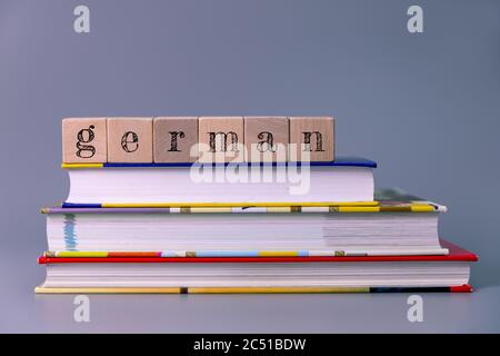 deutschkurs und Lernkonzept. Stapel von Büchern mit Holzblöcken Stockfoto