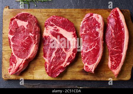 Vielfalt an frischen Black Angus Prime rohen Rindfleisch Steaks: Ribeye, Striploin, Chuck Roll und Picanha auf Holz Cutiing Board Stockfoto