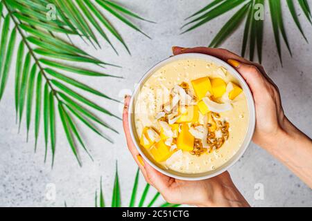 Tropische Mango und Kokosnuss Smoothie Schale, heller Hintergrund, Kopierraum. Stockfoto