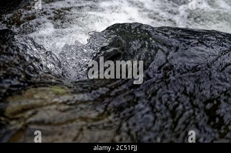 Nahaufnahme der Oberflächenstruktur von schnell wirbelnden Stromschnellen in einem Fluss Stockfoto