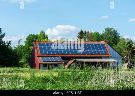 Grüner Energie mit Solarkollektoren auf dem Dach eines landwirtschaftlichen Gebäudes Stockfoto