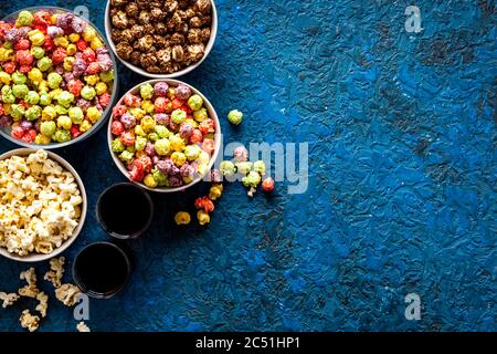 Set von aromatisiertem Popcorn und Soda auf blauem Tisch Draufsicht Kopierraum Stockfoto