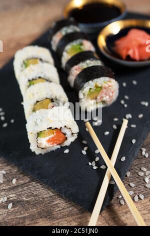 Sushi-Rolle auf dem schwarzen Teller. Japanisches Essen. Stockfoto