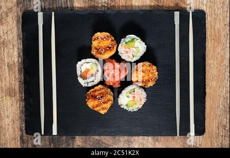 Sushi-Rolle auf dem schwarzen Teller. Japanisches Essen. Stockfoto