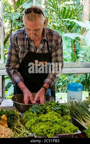 Senior man bereitet laotische Speisen mit frischen Zutaten bei der Tamarind Cookery School Class, Laos, Südostasien Stockfoto
