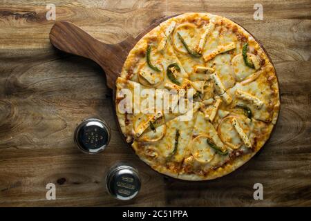 Pepperoni Pizza auf Holzbrett, Draufsicht auf leckere und knusprige vegetarische Pizza Margherita auf hellbraunem Tischhintergrund Stockfoto