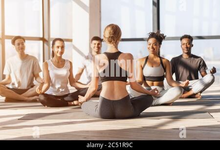 Professioneller Yoga Coach Mit Gruppe Junger Menschen, Die Gemeinsam Meditieren Stockfoto