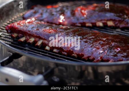 Selektive Fokusaufnahme der Baby-Rückenrippen auf einem Grill - perfekt für einen Food-Blog Stockfoto