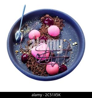 Dessert in Form eines Herzens und runde Kugeln in rosa Glasur mit Himbeermarmelade und Schokolade Figur in einem zerbröselten Keks auf einem Keramikplatte Stockfoto