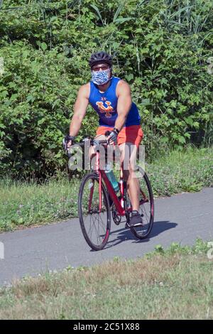 Ein fit muskulösen asiatischen Amerikaner trägt einen Sicherheitshelm & OP-Maske. In Kissena Park, Flushing, Queens, New York City. Stockfoto