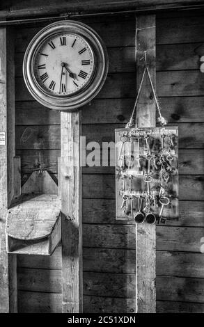 Alte Uhr mit Sammlung von alten komplizierten Tasten auf einem Brett Stockfoto