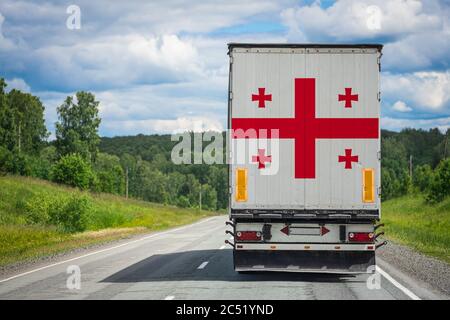 Ein LKW mit der Nationalflagge Georgiens auf der Hintertür zeigt Waren in ein anderes Land entlang der Autobahn. Konzept von Export-Import,tran Stockfoto