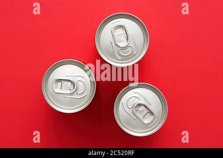 Getränke- oder Getränkedosen aus Aluminium mit Ziehring auf rotem Hintergrund. Ansicht von oben oder von oben. Stockfoto