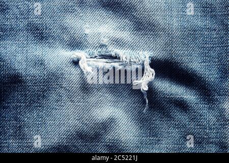 Zerrissene oder zerrissene alte Jeans in Denim-Blau. Nahaufnahme. Stockfoto