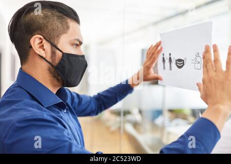 Geschäftsmann mit Maske fastet Hygienekonzept als Prävention gegen Infektion im Büro Stockfoto