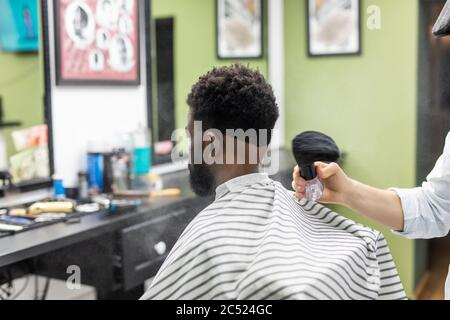 Coiffeur Coiffeur breitet Pulver auf Kunden Hals mit professionellen Rasierpinsel vor dem Schneiden der Haare mit Rasiermesser. Stockfoto