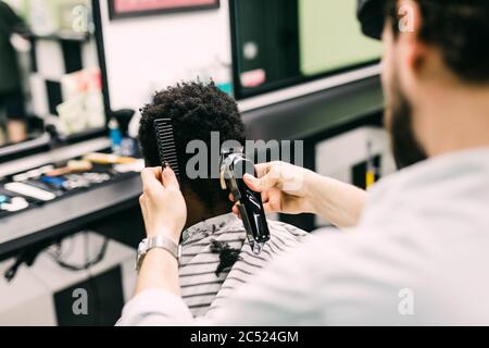 Portrait von jungen schwarzen Mann in barbershop.Handsome afrikanischen Kerl macht neue Frisur in Friseursalon. Stockfoto