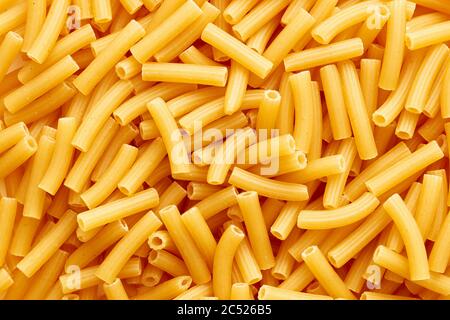 Haufen von rohen Tubini oder Ziti rigati Pasta. Ansicht von oben. Stockfoto