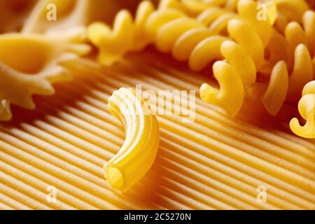 Verschiedene rohe Pasta oder Makkaroni in verschiedenen Arten und Formen. Makroansicht. Stockfoto