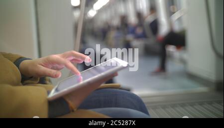 Frau in U-Bahn-Zug mit Tablet-PC Stockfoto