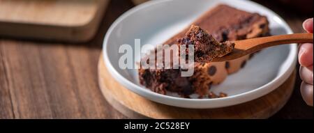 Schokoladengeschmack taiwanesische traditionelle Biskuitkuchen (taiwanesische castella kasutera) auf einem Holztablett Hintergrund Tisch mit Zutaten, close up. Stockfoto