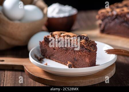 Schokoladengeschmack taiwanesische traditionelle Biskuitkuchen (taiwanesische castella kasutera) auf einem Holztablett Hintergrund Tisch mit Zutaten, close up. Stockfoto