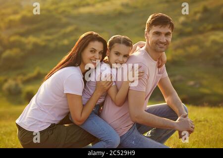 Porträt einer glücklichen Familie, die die Kamera über die Natur im Sommer betrachtet. Stockfoto