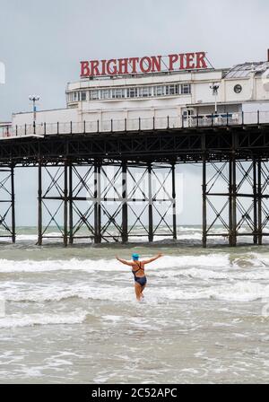 Brighton UK 30. Juni 2020 - Seebäder trotzen den Bedingungen in Brighton an einem nassen kalten und windigen Tag im Vergleich zu dieser Zeit letzte Woche, als die Sommerhitze mit Temperaturen über 30 Grad begann : Credit Simon Dack / Alamy Live News Stockfoto