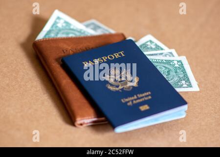 Konzeptfoto von amerikanischen Touristen, die US-Dollar ausgeben und durch Reisen nach dem Coronavirus. Amerikanischer Reisepass, Lederpass und Banknoten. Stockfoto