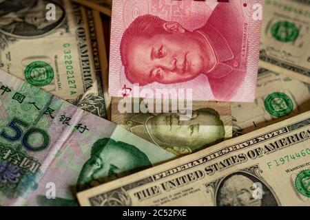 Konzept des US-China-Handelskrieges. Chinesische Renminbi (Yuan) Geldscheine mit grünen US-Dollar-Noten. Zeigt Handel, Handel, Importe, Exporte. Stockfoto