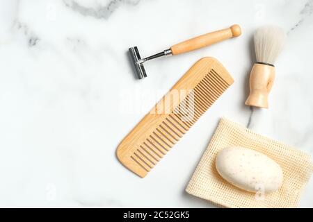 Umweltfreundliche Holz Rasierzubehör für Mann auf Marmortisch. Flach liegend, Draufsicht. Stockfoto