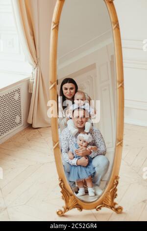 Porträt einer Familie, die vor einem großen Spiegel steht Stockfoto