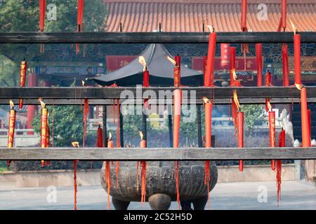 Rote Kerzen und Weihrauch brennen in einem traditionellen buddhistischen Tempel und Schrein in China. Stockfoto