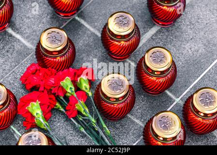 Nelken auf einer Marmorplatte und Begräbnislampen. Stockfoto