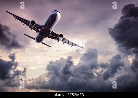 Modernes Verkehrsflugzeug fliegt zwischen dramatischen Wolken Stockfoto