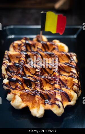 Belgische Waffel mit Chocholat-Sahne. Selektiver Fokus, enge Schärfentiefe. Belgische Flagge darin Stockfoto