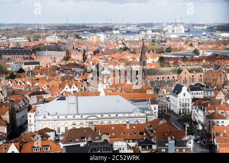 Brügge, Belgien 03/01/2020. Panoramablick auf die Altstadt von Brügge, Belgien. Rote Dächer, Bäume und ruhige Straßen darunter. Foto durch Zaunnetz aufgenommen. Stockfoto