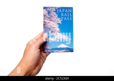 Penang, Malaysia - 25. Mai 2020 : Nahaufnahme einer Hand, die einen gebrauchten Japan Rail Pass auf rotem Hintergrund bei Gelugor hält Stockfoto