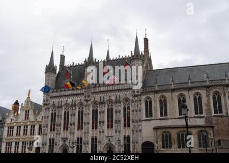 Burgplatz bei bewölktem Tag, altes Gebäude mit Fahnen und goldenen Ornamenten auf dem Dach. Stockfoto