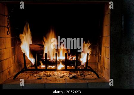 Brennendes Brennholz in einem Kamin, helle Flammen, ein Symbol für Wärme und Komfort im Haus Stockfoto