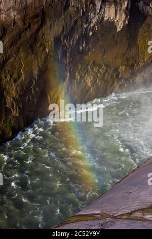 Ein Regenbogen, der die Orange River Gorge am Fuße des Augrabies Wasserfalls im Augrabies National Park, Südafrika, überspannt Stockfoto